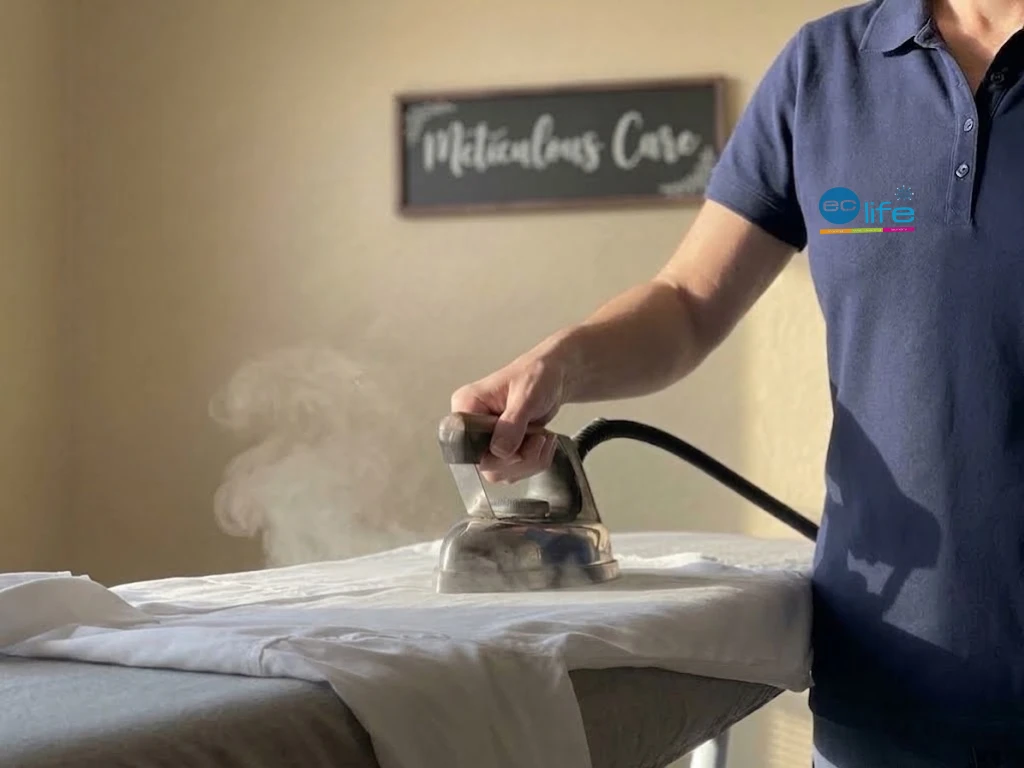 EcLife team member steam-ironing a garment by hand